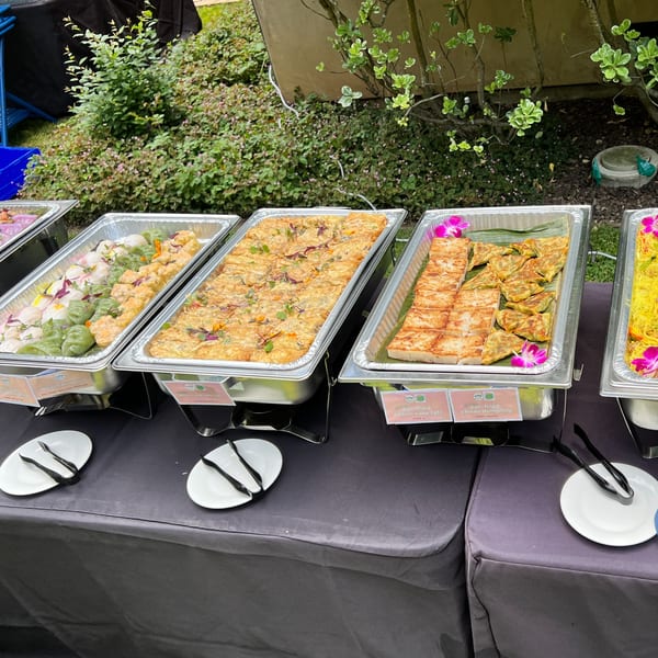 Buffet line with various Asian dishes, including dumplings, pan-fried daikon cake, and chives dumplings.