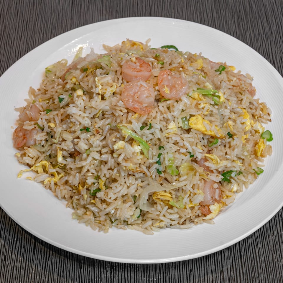 Imperial Garden's shrimp fried rice with egg, green onions, and cabbage on a white plate.